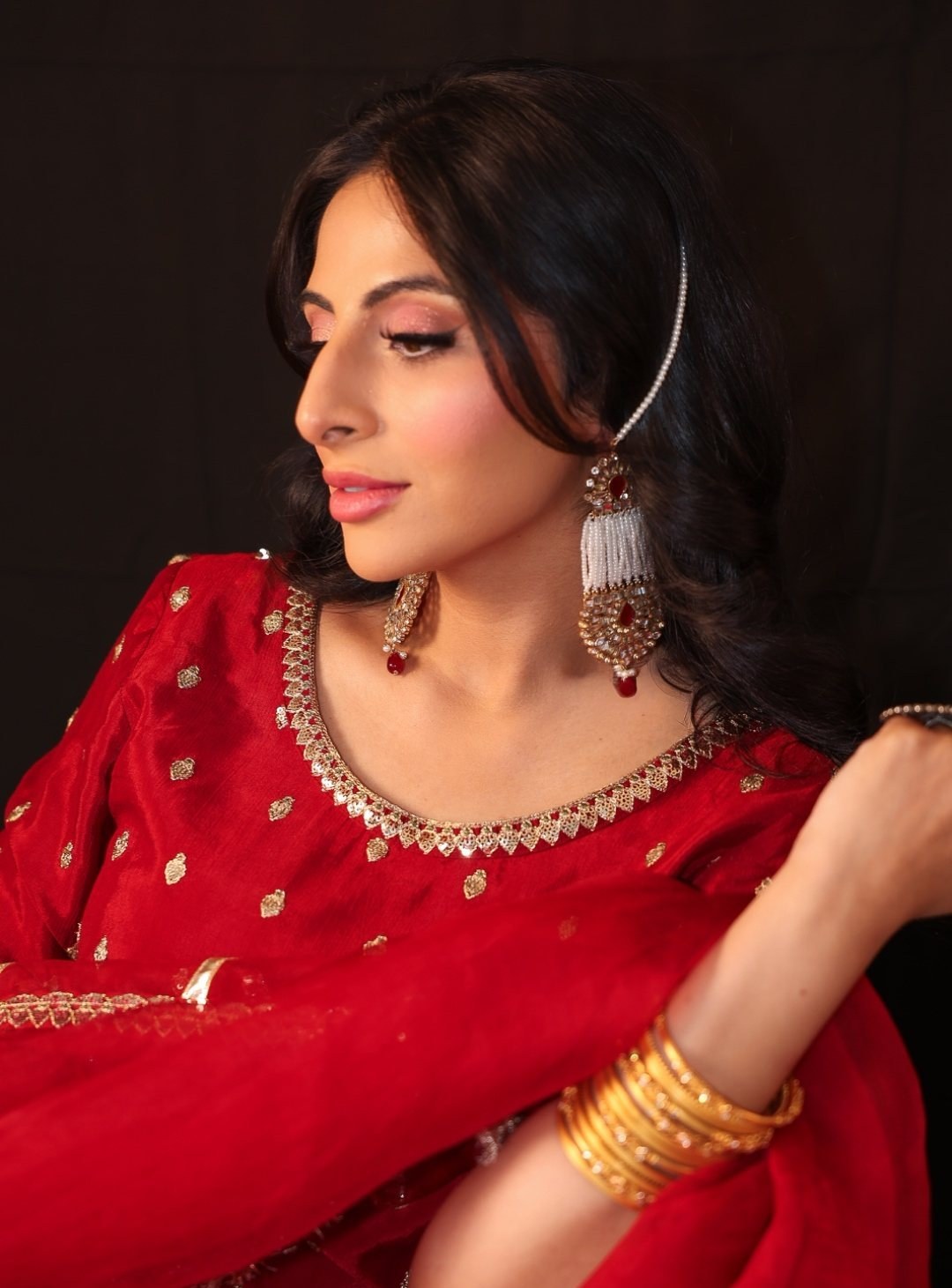 Hands and gold bangles against red silk