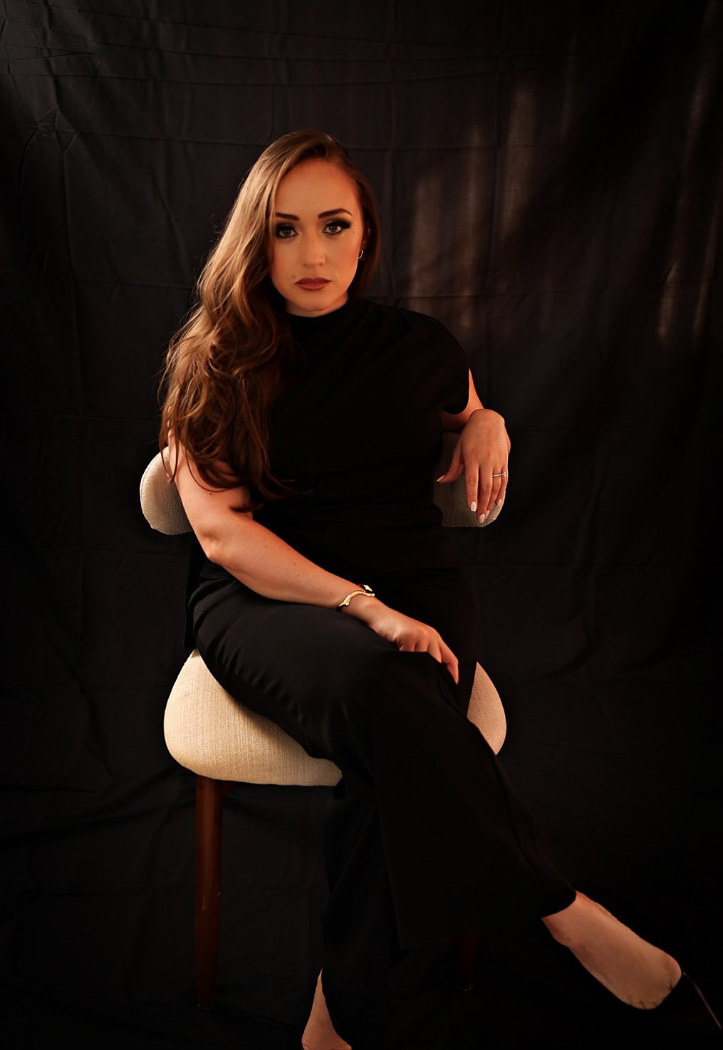 Katerina, founder of Met Expectations Photography, seated in the studio