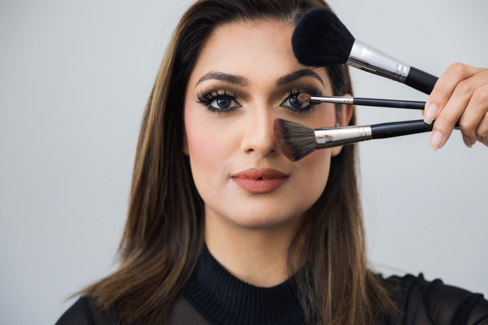 Brushes fanned across a face during a beauty session