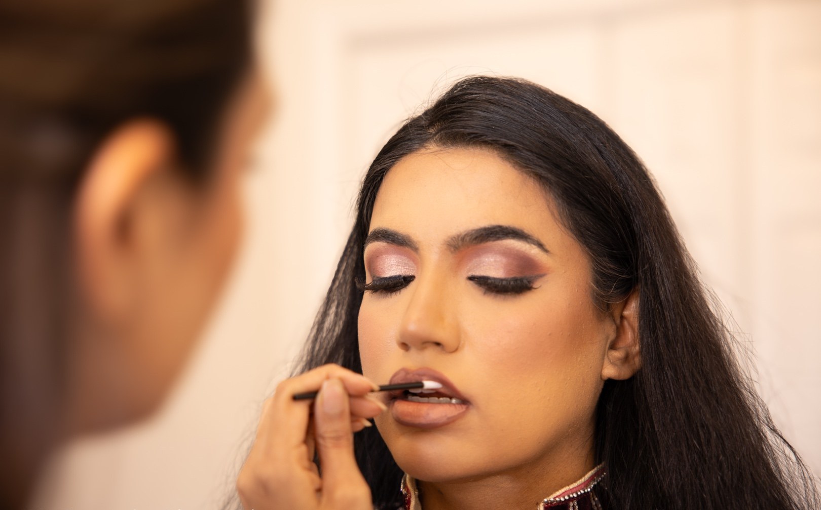 Lipstick being applied to a client, close in