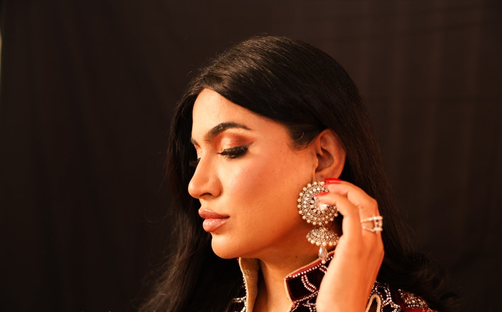 Profile with a hand raised to an earring